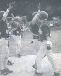 Catcher Dave Gibbons connects on a high five with Matt Smith whose home run broke open the game. Photo by Hans Schmidt